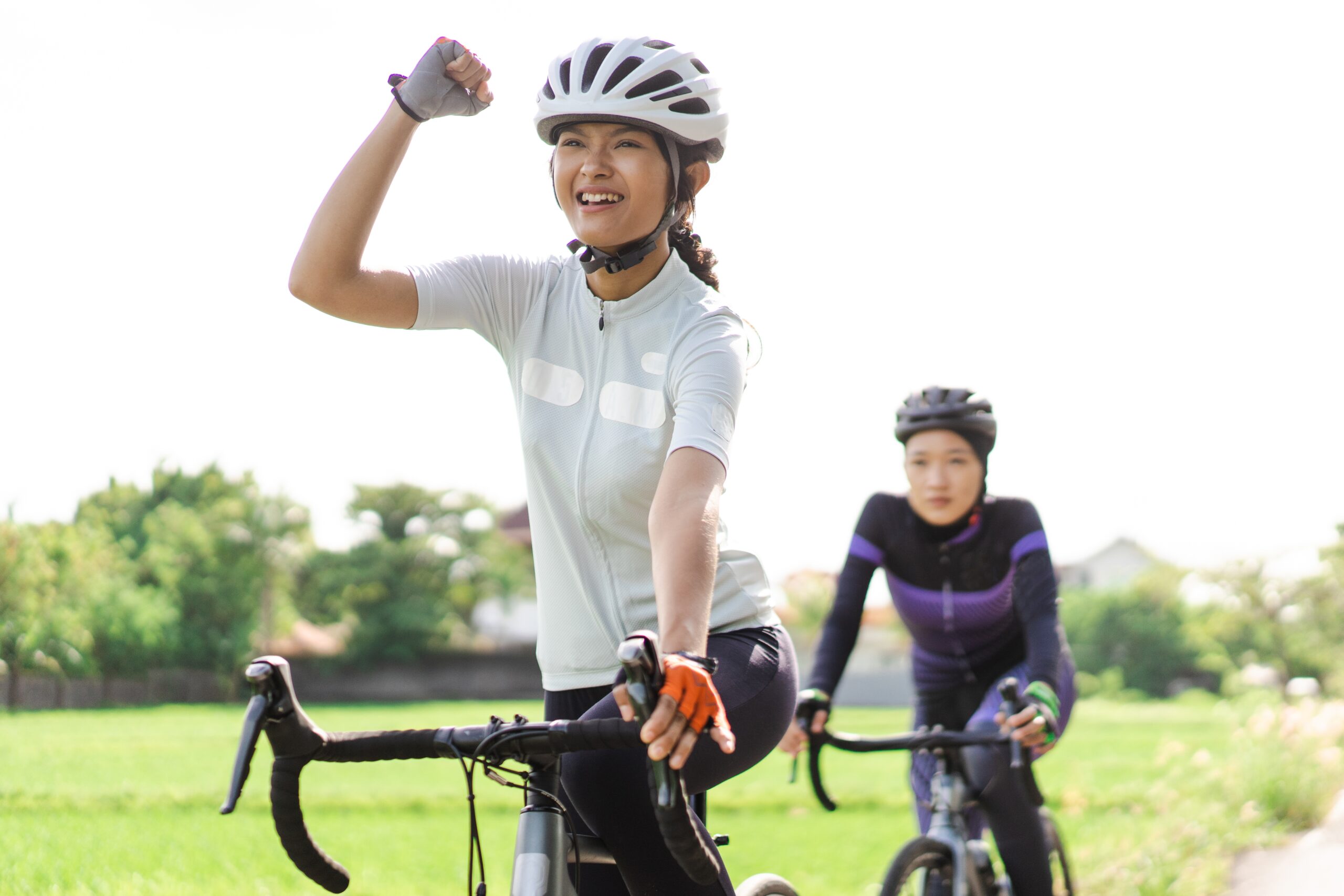 Excited,Young,Woman,Riding,Her,Road,Bike,With,Friend
